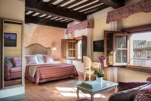 sypialnia z łóżkiem i kanapą w obiekcie Leon Bianco w mieście San Gimignano