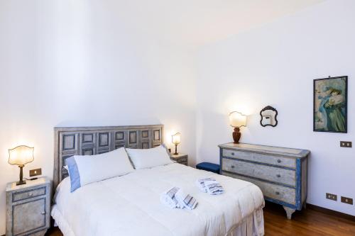 a bedroom with a white bed and two night stands at Fiesole's cozy Apartment 1 in Fiesole