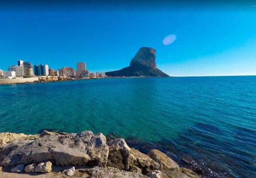 a view of the ocean with a mountain in the background at Apartment APOLO XIV in Calpe