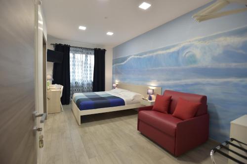 - une chambre avec un lit et une chaise rouge dans l'établissement MarBianco B&B, à Marina di Carrara