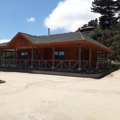 a large red house with a roof at Departamento Lago Vichuquen in Lago Vichuquen