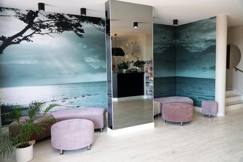a room with two chairs and a wall mural of a beach at Panorama_SPA in Trzęsacz