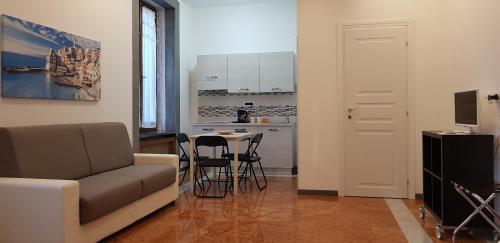 sala de estar con sofá, mesa y cocina en Il Giardino dei Limoni Room & Apartments en Génova