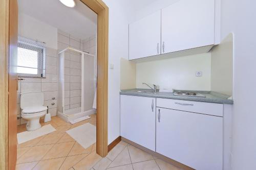 a white bathroom with a toilet and a sink at Villa Vukic in Vrsi
