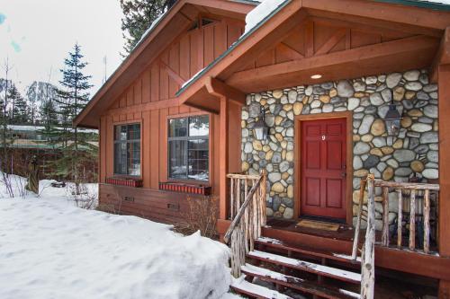 a log cabin with a red door in the snow at Black Bear Lodge in South Lake Tahoe