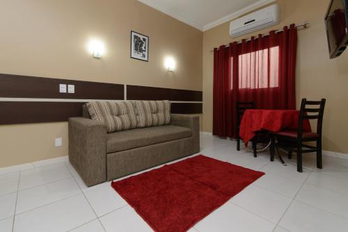 a living room with a couch and a red rug at Hotel São Bento in Marabá