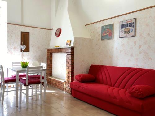 uma sala de estar com um sofá vermelho e uma mesa em La Loggetta em Celleno