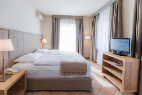 a hotel room with a bed and a television at Parkhotel Delta, Wellbeing Resort in Ascona