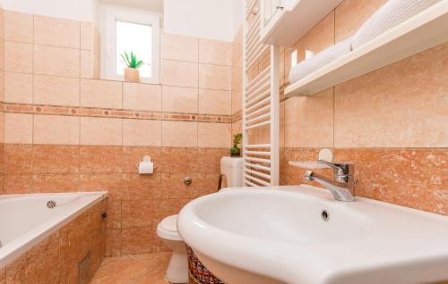 a bathroom with a sink and a toilet and a tub at Apartment Pavla with pool in Zadar