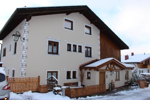 a large white building with a wooden fence in the snow at Haus Zegg in Nauders