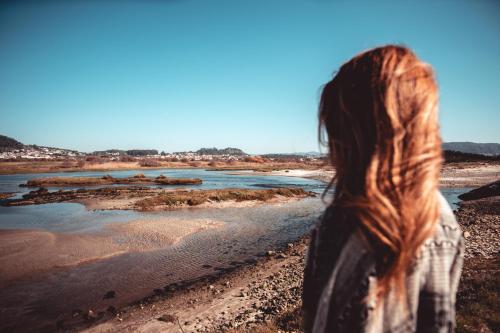 a woman standing on the beach looking at the water at Quintinha do Periqueiro in Castelo do Neiva
