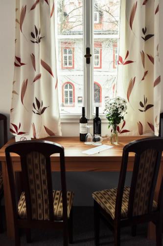 a window with two bottles of wine and two chairs at Resort U Fořta in Hřensko