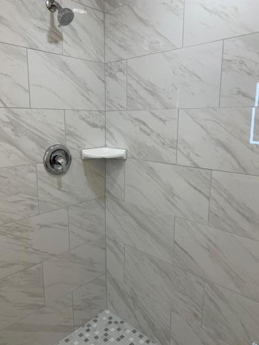 a bathroom with a shower with a glass door at Atlantic Shores Motel in Daytona Beach