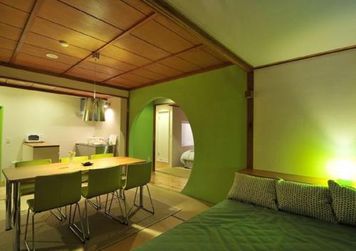 Cette chambre est dotée d'un mur vert, d'une table et de chaises. dans l'établissement Address Nozawa Executive Studio / Vacation STAY 22746, à Nozawa Onsen