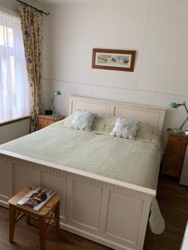 una camera da letto con un grande letto con fiori di Greenwoods cottage a Valkenburg