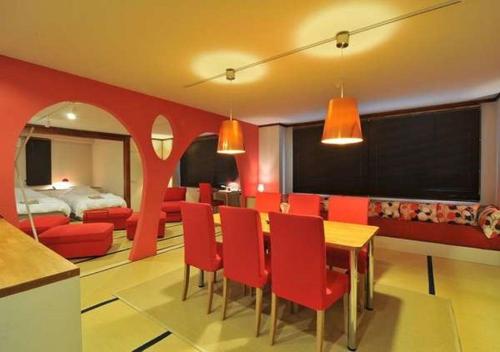 a dining room with red chairs and a bedroom at Address Nozawa Suite / Vacation STAY 22748 in Nozawa Onsen