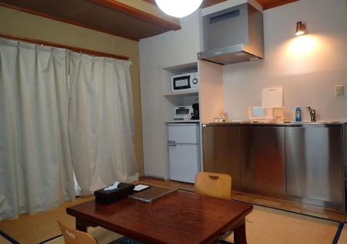 a kitchen with a wooden table and a refrigerator at Address Nozawa Japanese Room / Vacation STAY 22751 in Nozawa Onsen