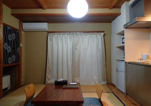 a room with a table and chairs and a window at Address Nozawa Japanese Room / Vacation STAY 22751 in Nozawa Onsen