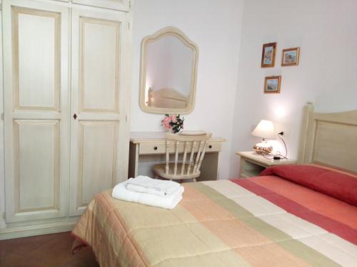 a bedroom with a bed and a desk with a mirror at Appartamenti da Ermanno in Bonassola