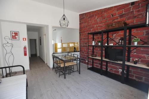 a living room with a brick wall and a table with chairs at Lagos Central Apartments Ap 14 in Lagos