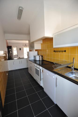 una cucina con armadietti bianchi e pavimento piastrellato nero di Lagos Central Apartments Ap 14 a Lagos