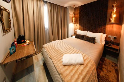 Una habitación de hotel con una cama con una toalla. en Hercules Boutique Hotel en Ceuta