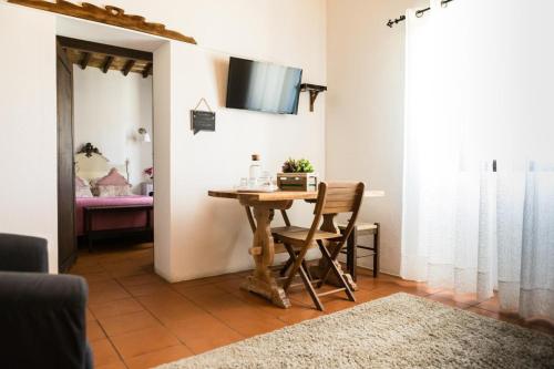 ein Esszimmer mit einem Tisch und einem TV an der Wand in der Unterkunft Carrança Lounge in Évora