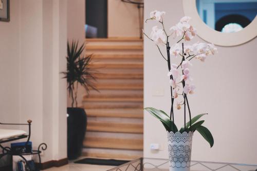 un vase rempli de fleurs sur une table dans un couloir dans l'établissement Il Bottone D'Argento, à Gaète