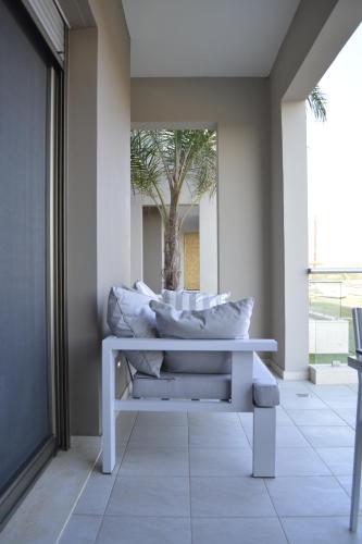 a white bench with pillows on it in a hallway at Double Bay Beach Hotel in Elafonisos