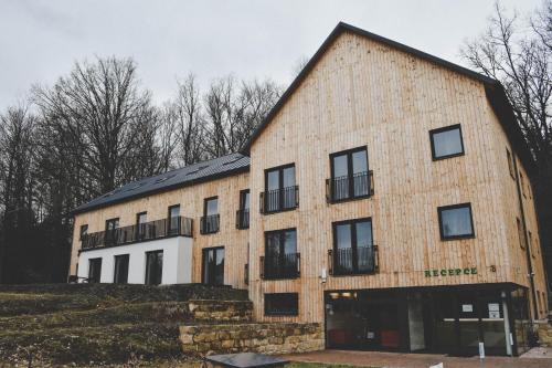 a large brick building with a gambrel roof at Resort U Fořta in Hřensko