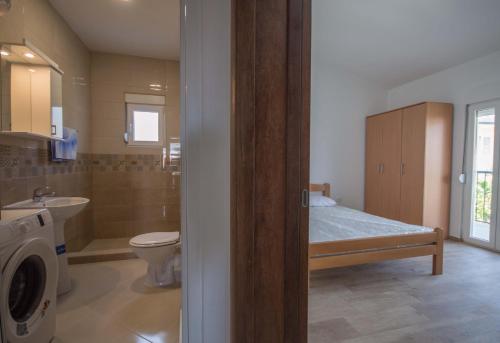 ein Bad mit einem Bett, einem WC und einem Waschbecken in der Unterkunft 6 + 1 person , 2 rooms in Bar