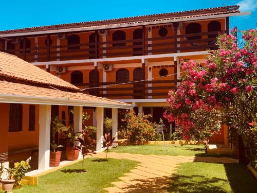 a building with a yard with pink flowers at Pousada Paradise in Alcobaça