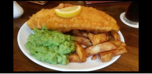a plate of food with a sandwich and french fries at The Royal George Staithes in Staithes