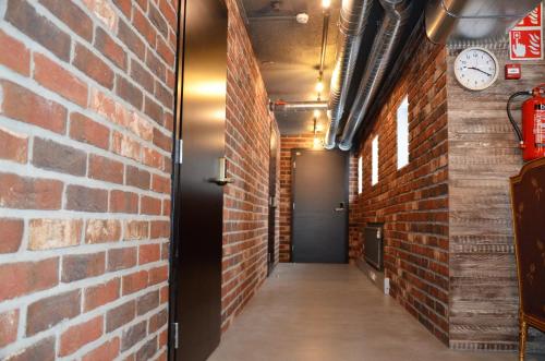 a corridor with a brick wall and a door at Loft Family Hotel in Imatra