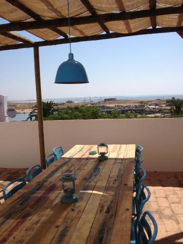 a wooden table with a view of the ocean at Boutique Taghostel in Lagos