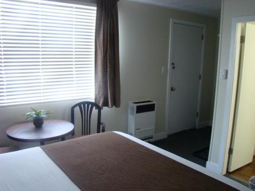 1 dormitorio con cama, mesa y ventana en Paddock Inn, en Coleman