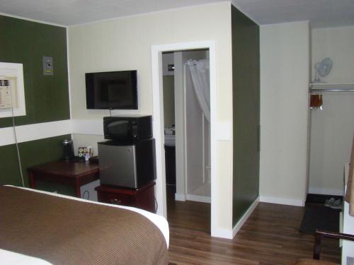 a room with a bedroom with a bed and a television at Paddock Inn in Coleman