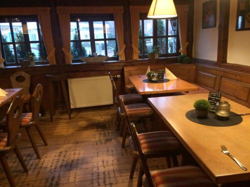 a restaurant with wooden tables and chairs and windows at Franziskaner am Markt in Löningen