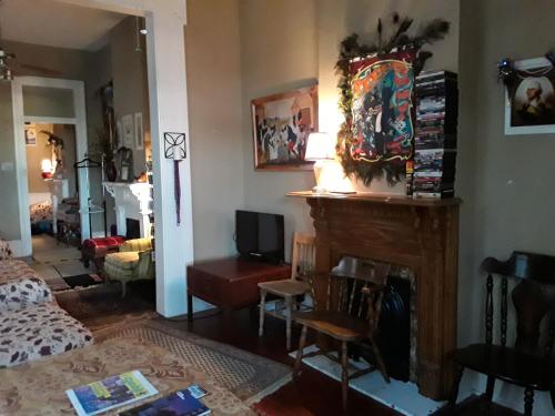 a living room with a fireplace and a bedroom at Creole Victorian for groups large and small in New Orleans
