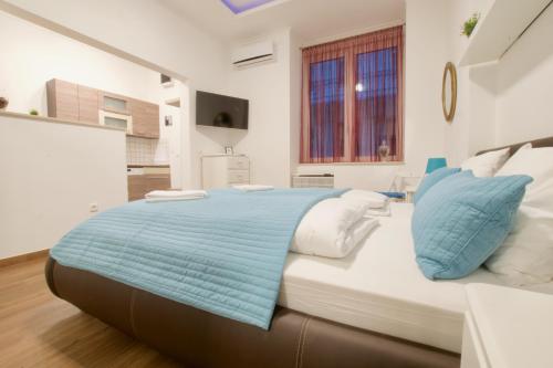 a bedroom with a large bed with blue and white pillows at Standard Apartment by Hi5 -Baross Square in Budapest