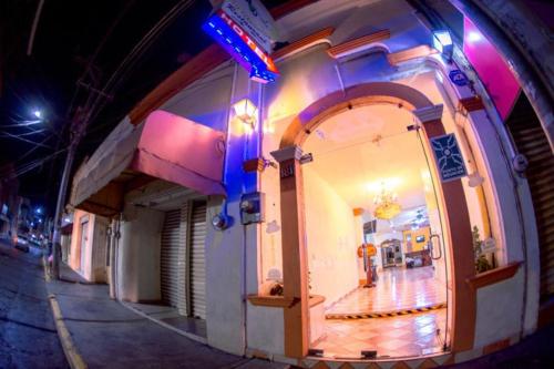 a building with an archway on a street at night at Hotel Los Girasoles in Tepic