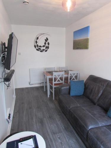 a living room with a couch and a table at The Annex Apartment in Weymouth