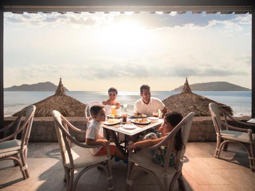 a family eating food at a table on the beach at El Cid Castilla Beach in Mazatlán