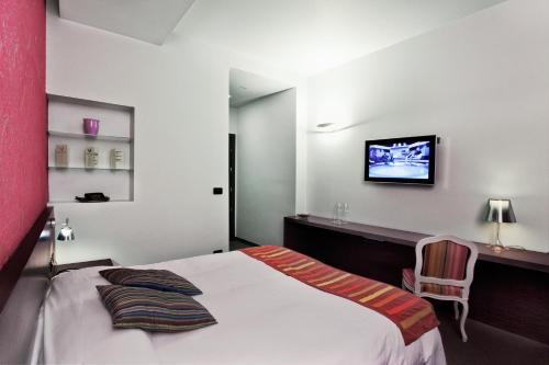 a bedroom with a bed and a tv on a wall at MA Hotel in Santa Margherita Ligure