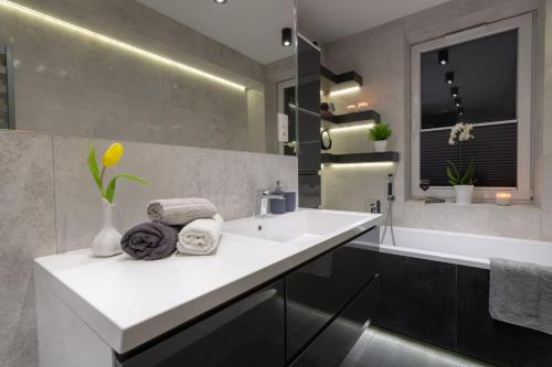 a bathroom with a white sink and a bath tub at Cisza in Ustrzyki Dolne