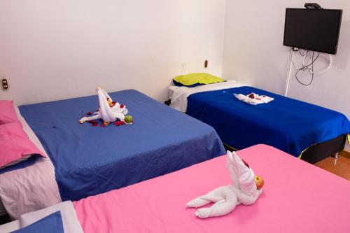 a room with two beds with stuffed animals on them at Hotel Quintas de Bogotá in Bogotá