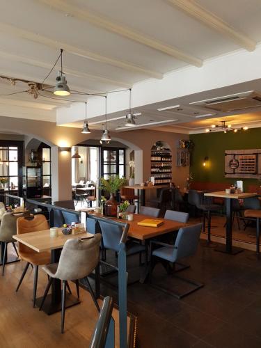 Hotel Restaurant 't Trefpunt في ميد: مطعم فيه طاولات وكراسي في الغرفة