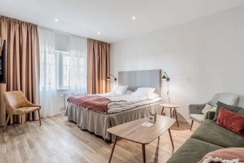 a hotel room with a bed and a couch at Blommenhof Hotel in Nyköping