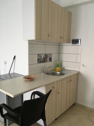 a kitchen with a counter and a sink and a chair at Ria mare in Qeparo