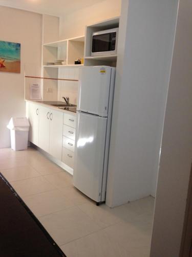 a white refrigerator freezer sitting in a kitchen at Chez Noosa Resort Motel in Sunshine Beach